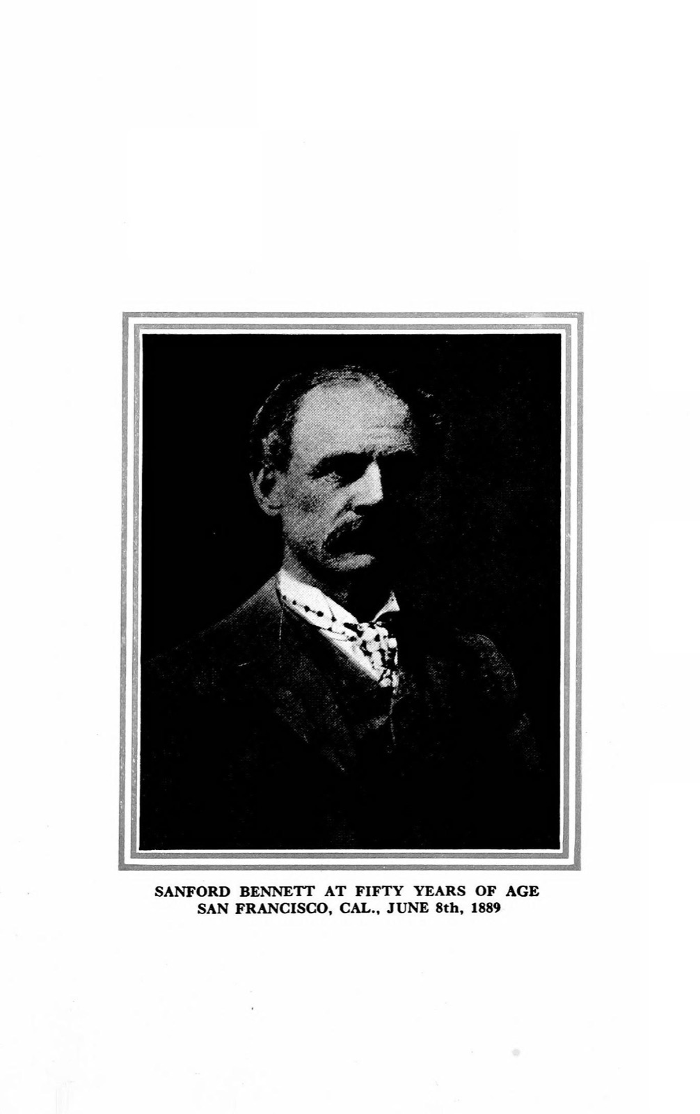 Black-and-white half-length photographic portrait of a gaunt middle-aged man with a moustache and sunken cheeks, in a dark coat and patterned cravat, against a dark ground.