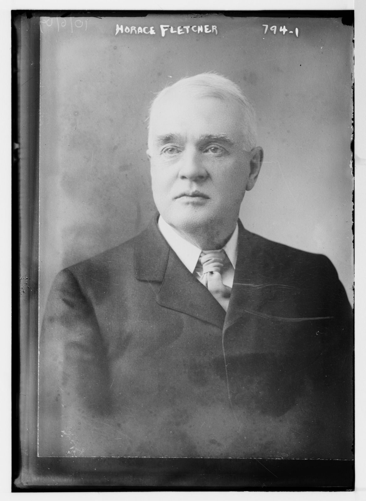 Black-and-white half-length portrait photograph of Horace Fletcher, an older man with grey hair, clean-shaven, in a dark suit and tie.