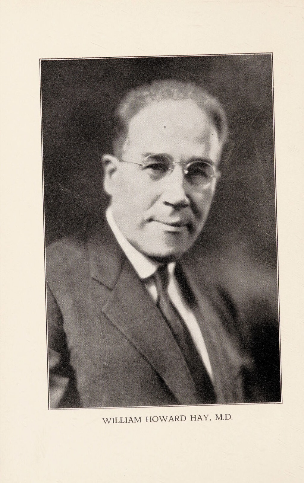 Black-and-white bust portrait of an older man with round spectacles, a high forehead, and a dark suit and tie, facing slightly forward; printed caption below reads William Howard Hay, M.D.