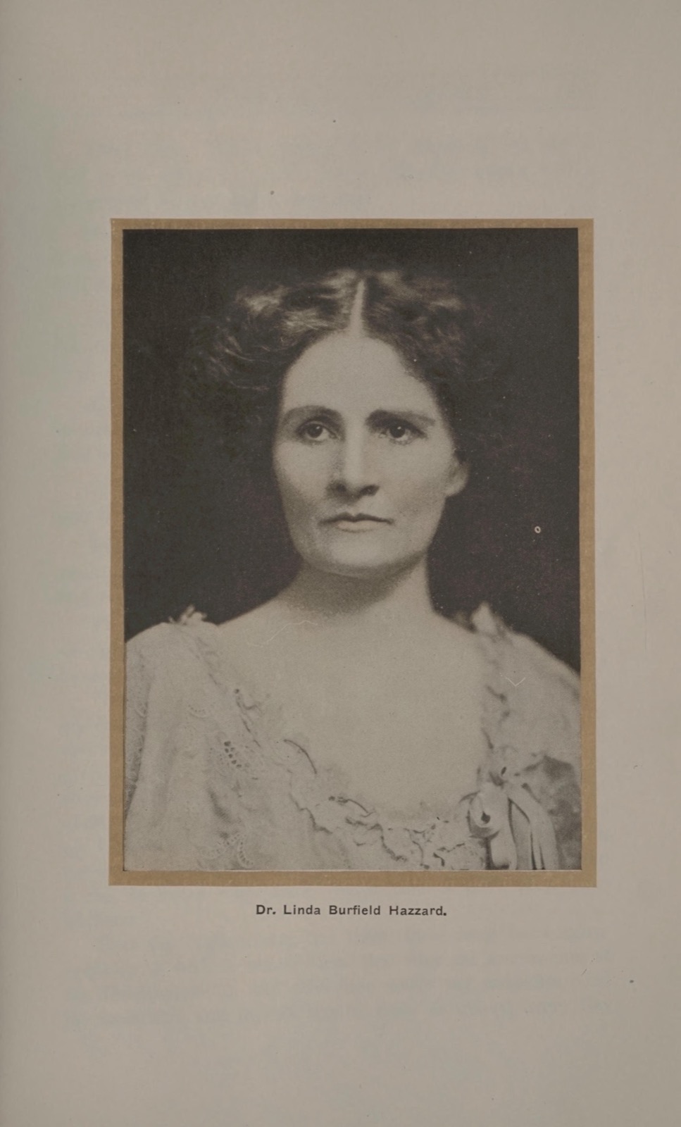 Studio bust portrait of a woman in a light embroidered dress, her dark hair parted in the center and waved, printed below with the caption 'Dr. Linda Burfield Hazzard' on a 1920 encyclopedia plate.