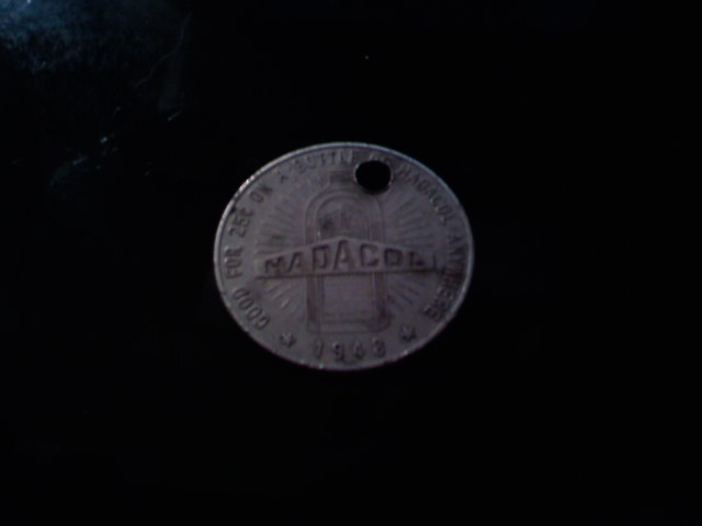 The back face of the same worn metal trade token, showing a bottle silhouette, the word 'HADACOL', the date '1948', and partly worn text offering 25 cents toward a bottle of Hadacol.