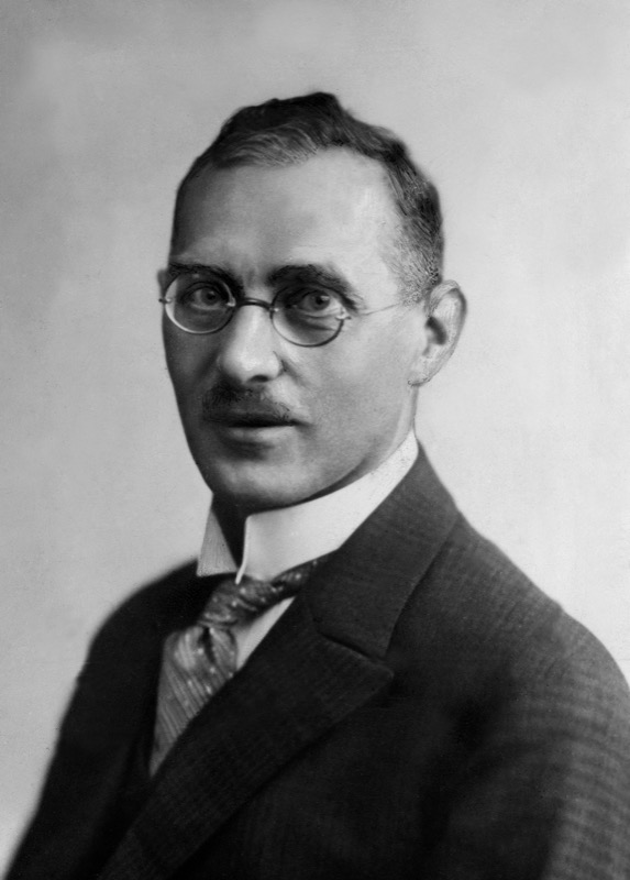 Black-and-white studio portrait of Max Gerson in a dark suit, tie, round glasses, and high white collar.