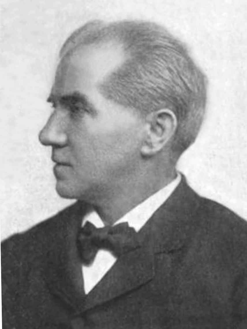 Black-and-white studio profile portrait of an older clean-shaven man with swept-back grey hair, wearing a bow tie and dark coat.